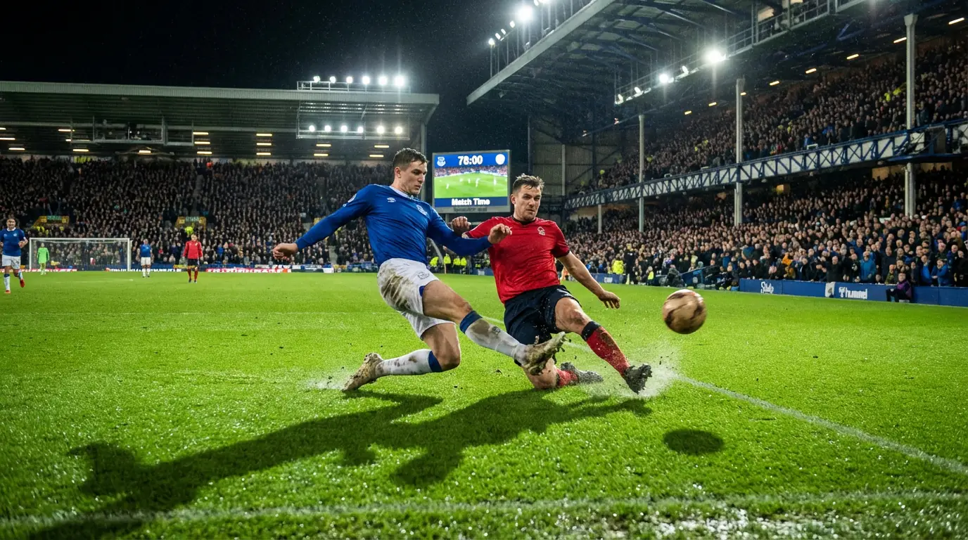 Voetbalwedstrijd in volle gang op een verlicht stadionveld met spelers in actie en een vol publiek